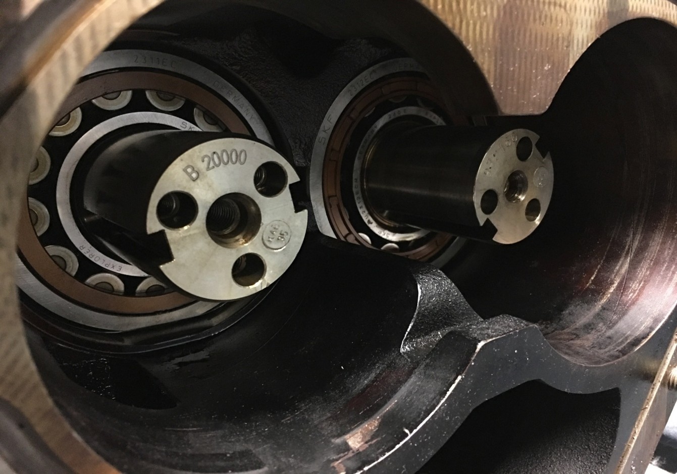 Internal components of a refrigeration compressor showing bearings and metal shafts