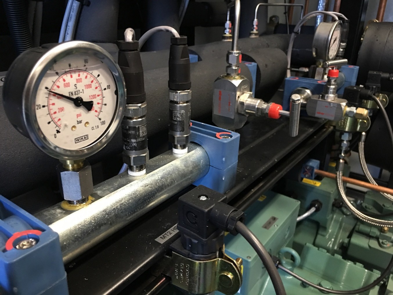 Pressure gauges, valves and pipework inside a commercial refrigeration plant room