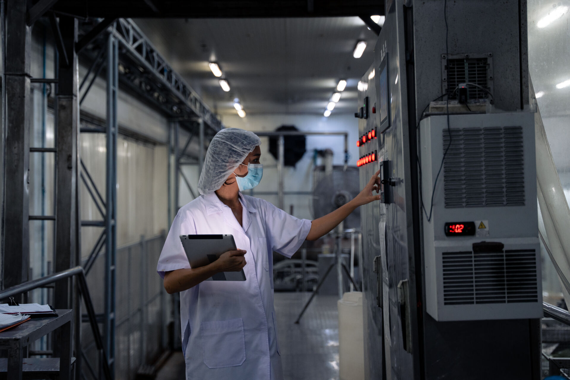 Coldcase temperature controlled food storage area with a worker checking refrigeration equipment