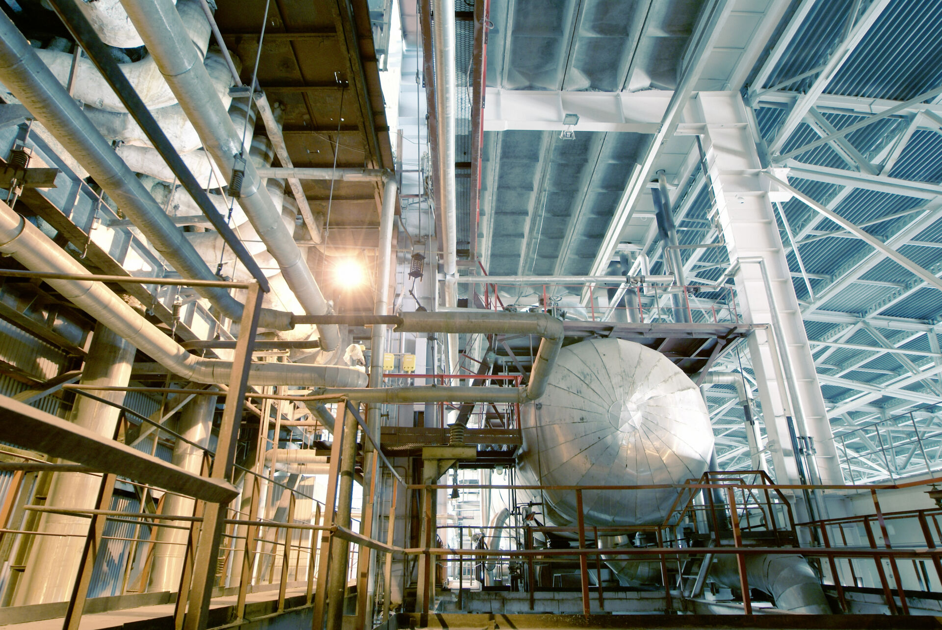 Coldcase industrial plant room with overhead pipework, cables and refrigeration equipment