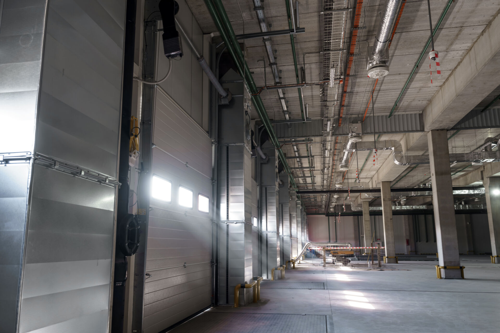 Coldcase cold storage warehouse interior with large insulated doors and overhead pipework