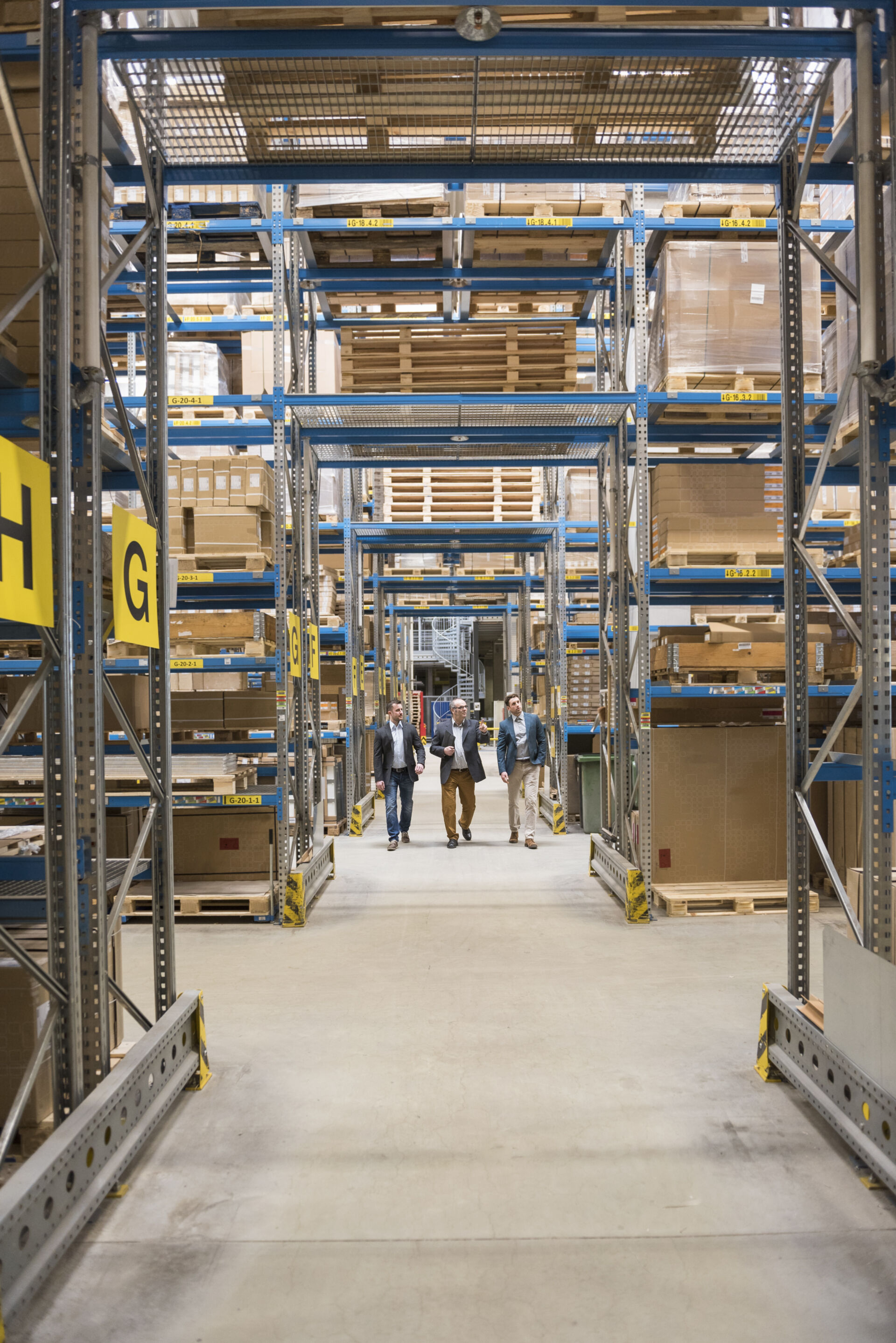 Coldcase warehouse aisle with high racking and workers walking through the facility
